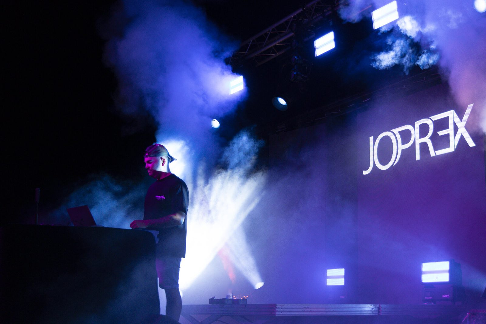 JO PREX en live sous les projecteurs bleus et fumée, logo JOPREX en arrière-plan, photo Martine Jamin