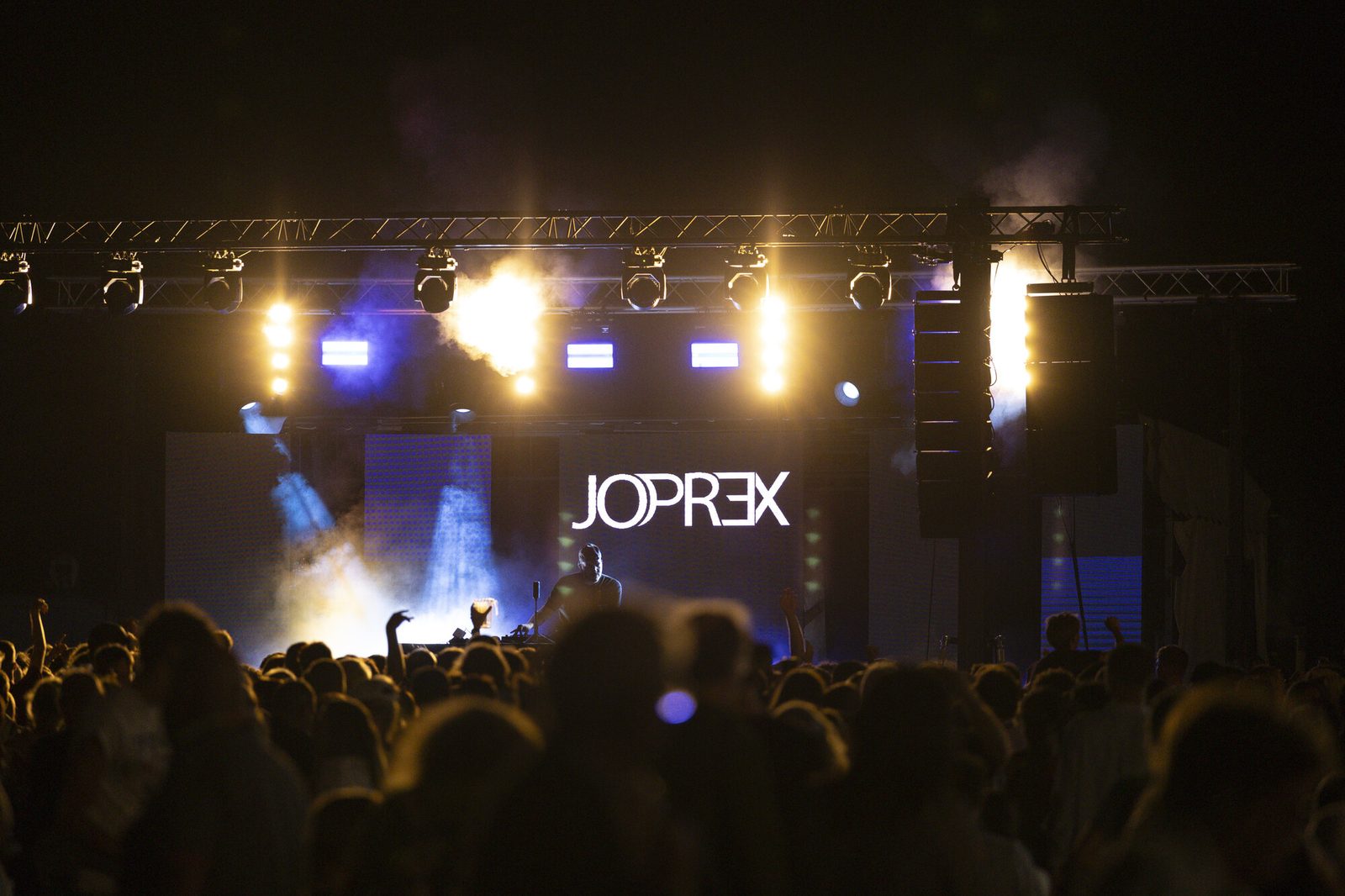 JO PREX en plein set avec effets pyrotechniques et foule en avant-plan, photo Martine Jamin